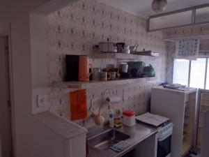 a small kitchen with a sink and a refrigerator at O coração de Ubatuba in Ubatuba