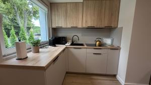 a kitchen with white cabinets and a sink and a window at Apartaments Rocha 159 - Blisko Jasnej Góry - free parking in Częstochowa