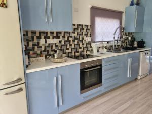 a kitchen with blue cabinets and a sink at "Chez Maria" in Stroumbi