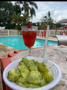a plate of food with a fork and a drink at Chácara Recanto in Jarinu