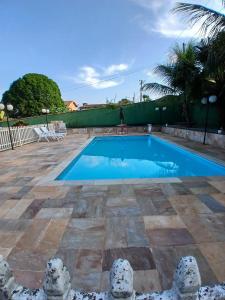 a swimming pool with blue water in a yard at Chácara Recanto in Jarinu +21 photos