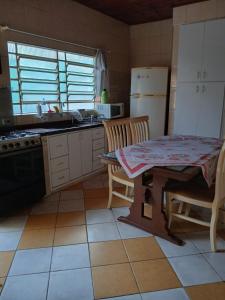 a kitchen with a table and a table and a refrigerator at Chácara Recanto in Jarinu