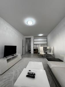 a living room with a couch and a television at Nest Apartments - FK Commodity in Kosovo Polje
