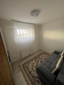 a living room with a couch and a rug at Nest Apartments - FK Commodity in Kosovo Polje +2 photos