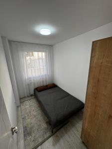 a small room with a bed and a window at Nest Apartments - FK Commodity in Kosovo Polje