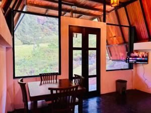 a dining room with a table and a large window at Bambarakanda eco resort in Welegama