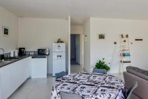 a kitchen and a table in a room with a table and a kitchen sidx sidx at Gîte des Lauriers Roses in Laurac-en-Vivarais