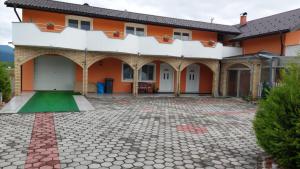 an orange and white house with a courtyard at 1 Room Apartment Kuckovic in Bihać
