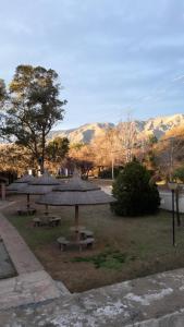 two picnic tables with umbrellas in a park at Posada in Merlo
