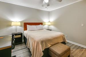 1 Schlafzimmer mit einem Bett, einem Schreibtisch und 2 Lampen in der Unterkunft Less Than 2 Mi to ECU and Medical District Retreat with Patio in Greenville
