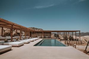 a resort with a swimming pool and lounge chairs at MIRA Earth Studios in Valle de Guadalupe
