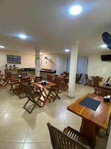 a dining room with wooden tables and chairs at Buriti Hotel Aracruz in Aracruz +21 photos