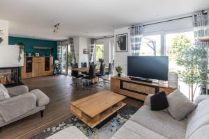 a living room with a large flat screen tv at Ferienhaus Thiele - Familienglück mit Garten - Kamin - Sauna - Pool in Weimar