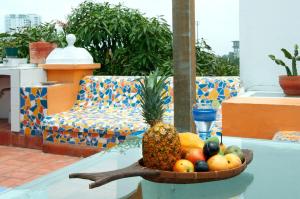 a bowl of fruit on a table with a pineapple at Colonial Luxury Oasis In Cartagena's Old City in Cartagena de Indias
