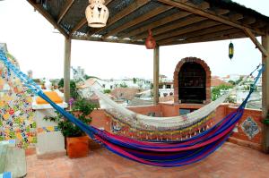 a hammock on a patio with a roof at Colonial Luxury Oasis In Cartagena's Old City in Cartagena de Indias