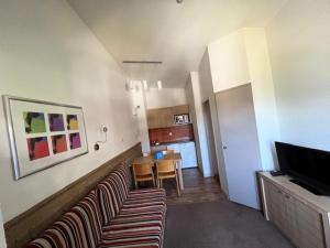 a living room with two couches and a television at Résidence Le Britania - maeva Home - Appartement 2 pièces 4 personnes - Sélection MAE-6673 in La Tania