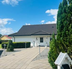a white house with a bench in front of it at Charmende villa in Herning
