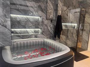 a bathroom with a tub filled with red roses at Alojamiento MEL BEACH in Arinaga