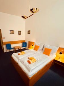 a bedroom with a large bed with orange pillows on it at Penzion Ludor in Strážnice