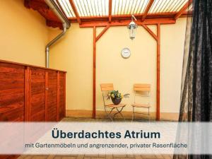 une chambre avec deux chaises et une horloge sur le mur dans l'établissement Villa Beethoven mit Ladestation, à Zinnowitz