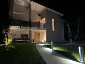 a house lit up at night with a pathway at Apartments Wally in Ptuj