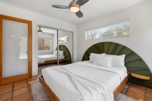 a bedroom with a large bed and a mirror at The Ricardo! Mid-Century Villa with Saltwater Pool in Palm Springs +43 photos