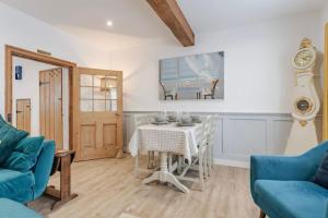 un salon avec une table et un canapé bleu dans l'établissement Chalk Reef Cottage - Sheringham Cottages, à Sheringham 17 autres photos