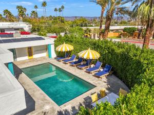 an overhead view of a swimming pool with chairs and umbrellas at The Ricardo! Mid-Century Villa with Saltwater Pool in Palm Springs