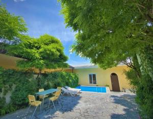 a patio with a table and chairs in front of a house at Lux Villa Yerevan in Yerevan