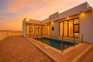 a villa with a swimming pool in the desert at Remal Resort Bidiyah in Badīyah