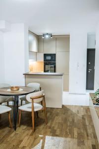 a kitchen and dining room with a table and chairs at New Bubanj Apartment's in Kragujevac