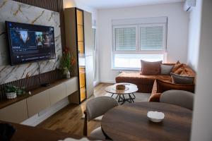 a living room with a couch and a table at New Bubanj Apartment's in Kragujevac