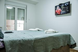 a bedroom with a bed with two towels on it at New Bubanj Apartment's in Kragujevac