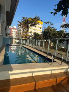 una piscina sul lato di un edificio di Piscina,sauna ,ar condicionado a 30passos da Bacutia a Guarapari