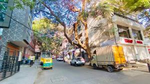 a city street with a tree and cars on the road at ELO House - Spacious 2BHK Apartment with Kitchen, Malleswaram in Bangalore