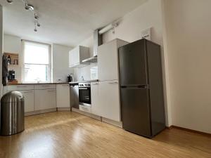 a kitchen with a stainless steel refrigerator and white cabinets at Tobi‘s Ferienapartment in Gottmadingen