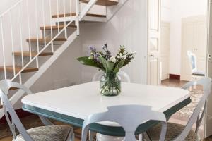 a white table with a vase of flowers on it at B&B MATINE' Suits & Rooms in Matino +14 photos