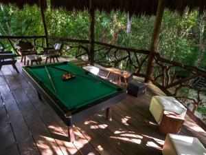 una mesa de billar en la terraza de una casa en Jolie Jungle Eco Hotel, en Puerto Morelos