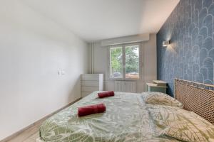 サン・モール・デ・フォッセにあるSaint-Maur Appartement Calme et Confortable, RER A, Bords de Marneのベッドルーム1室(赤い枕が付いた大型ベッド1台付)