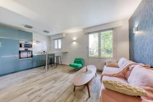 サン・モール・デ・フォッセにあるSaint-Maur Appartement Calme et Confortable, RER A, Bords de Marneのソファとテーブルのあるリビングルーム