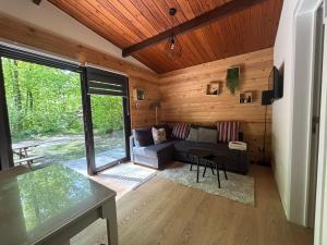 a living room with a couch and a table at Forest Lodge in Petit Mesnil