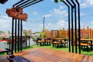 a patio with tables and chairs and a fence at Casa Chetumal Hotel in Chetumal