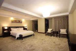 a hotel room with a bed and a table and chairs at Guangzhou Jin Wan Li Business Hotel in Guangzhou +34 photos