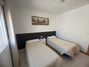 two beds in a small room with a window at Hostal Las rejas in Archidona +15 photos