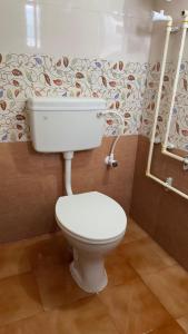 a bathroom with a white toilet in a room at I grand Home Stay in Tallākulam +7 photos