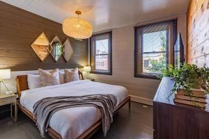 a bedroom with a bed and a lamp and windows at Chic Home with King Bed and Fire Pit in Pittsburgh