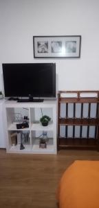 een flatscreen-tv op de top van een wit entertainment center bij À Perte De Vue 50 m de la mer climatisé linge de maison inclus in Empuriabrava +16 foto's