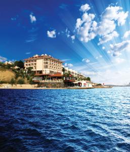 a building on the shore of a large body of water at Family Resort Hotel in Selimpasa
