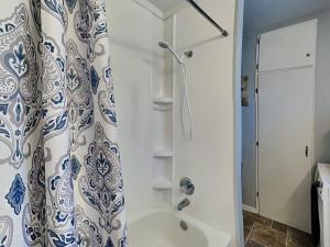 a bathroom with a shower and a shower curtain at Knotty Pines Cabin in Ruidoso +8 photos