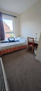 Un dormitorio con una cama con ventana y un escritorio. en Cosy Room with Shared Bathroom, en Edimburgo